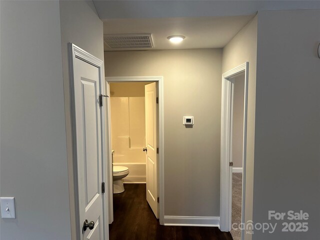 hall with dark wood-style flooring and baseboards