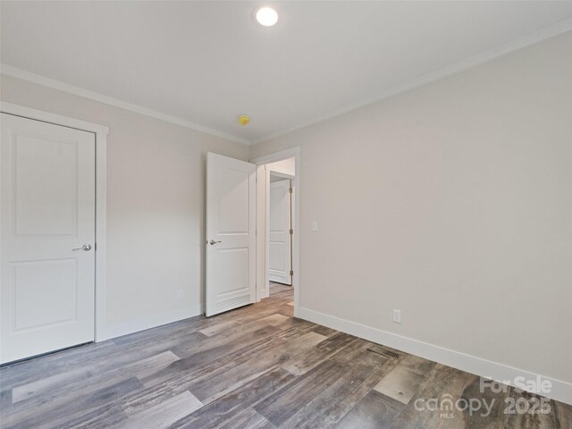 255 Thompson Cove Rd, Clyde, NC 28721 - unfurnished bedroom featuring wood finished floors, crown molding, and baseboards