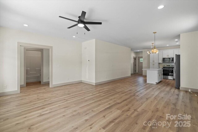 unfurnished living room featuring recessed lighting, light wood-type flooring, ceiling fan, and baseboards