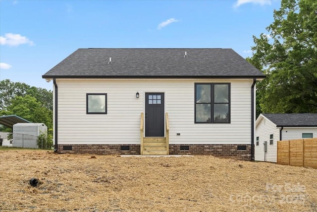 view of front of home with entry steps, crawl space, a shingled roof, and fence