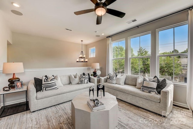 living room with a chandelier, a ceiling fan, recessed lighting, and wood finished floors