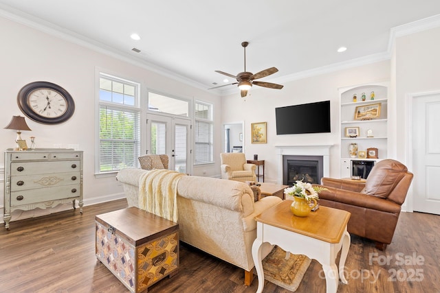 7016 Bareland Rd, Fort Mill, SC 29707 - living area featuring crown molding, dark wood-type flooring, a ceiling fan, a glass covered fireplace, and recessed lighting