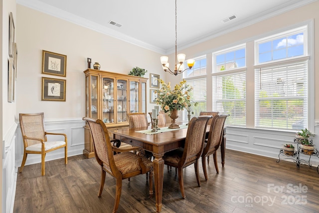 7016 Bareland Rd, Fort Mill, SC 29707 - dining room with a chandelier, healthy amount of natural light, dark wood-type flooring, ornamental molding, and a wainscoted wall
