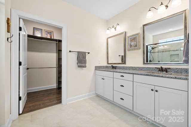 7016 Bareland Rd, Fort Mill, SC 29707 - full bathroom featuring a stall shower, double vanity, tile patterned floors, a walk in closet, and baseboards