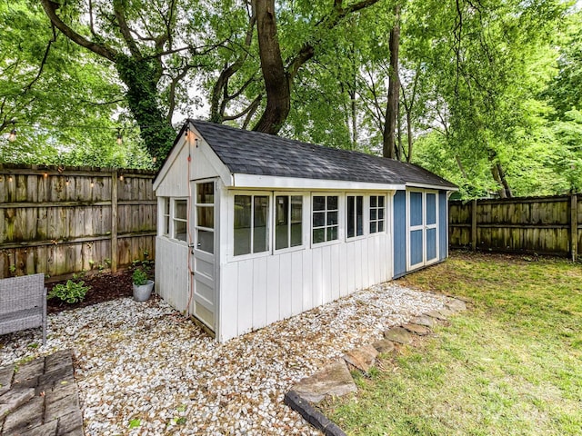 view of outbuilding with a fenced backyard and an outbuilding