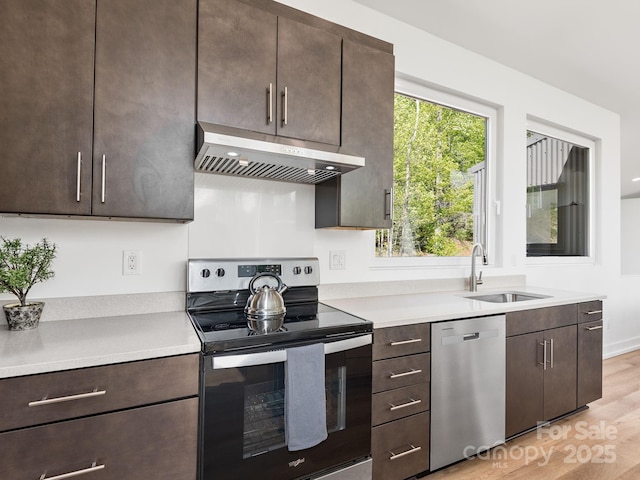 85 S Fork Trl, Lake Toxaway, NC 28747 - kitchen featuring stainless steel appliances, under cabinet range hood, a sink, light wood-style floors, and light countertops