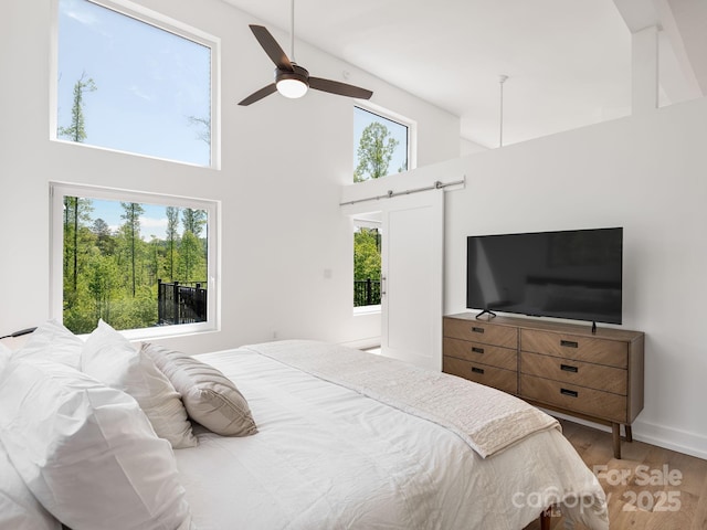 85 S Fork Trl, Lake Toxaway, NC 28747 - bedroom featuring a high ceiling, multiple windows, wood finished floors, and ceiling fan