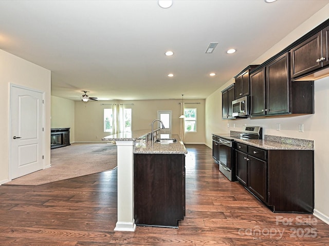 9027 Gray Willow Rd, Charlotte, NC 28227 - kitchen with stainless steel appliances, a sink, dark wood-style floors, light stone counters, and recessed lighting