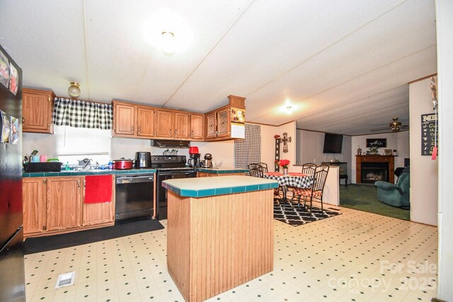 1574 Burke Duncan Rd, Lancaster, SC 29720 - kitchen with black appliances, tile countertops, a fireplace, a kitchen island, and a ceiling fan