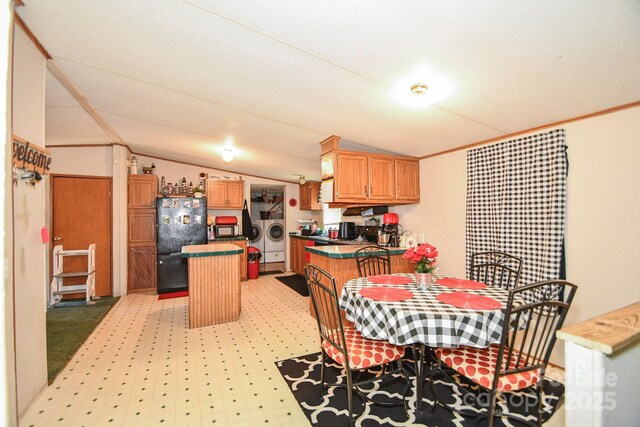 1574 Burke Duncan Rd, Lancaster, SC 29720 - kitchen with black appliances, washer and dryer, lofted ceiling, light floors, and a center island