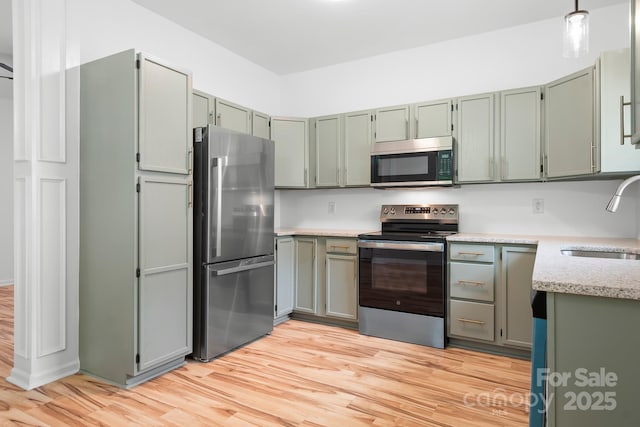 4719 Sahalee Ln, Charlotte, NC 28216 - kitchen with appliances with stainless steel finishes, light wood-type flooring, and light stone counters
