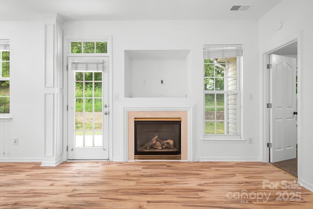 4719 Sahalee Ln, Charlotte, NC 28216 - unfurnished living room featuring wood finished floors, a glass covered fireplace, and healthy amount of natural light