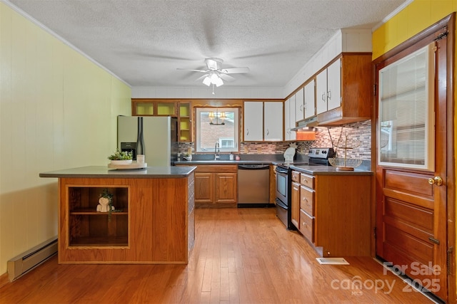 1405 8th Ave NW, Conover, NC 28613 - kitchen with appliances with stainless steel finishes, a baseboard heating unit, dark countertops, light wood-style flooring, and crown molding