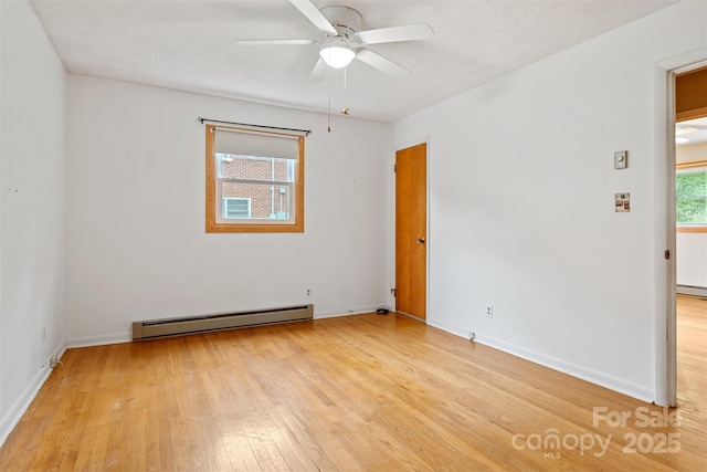 1405 8th Ave NW, Conover, NC 28613 - spare room with a baseboard heating unit, light wood-style floors, a ceiling fan, and baseboards