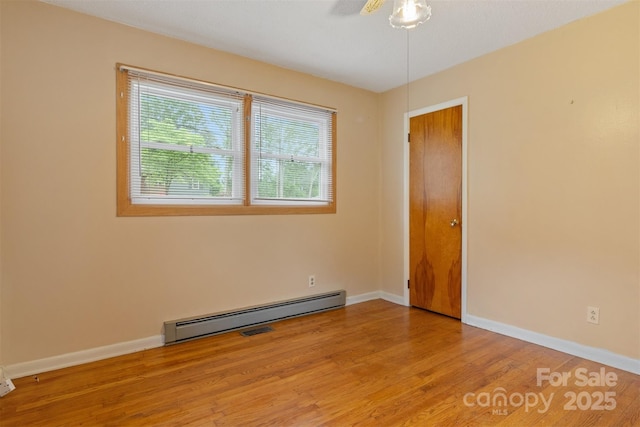 1405 8th Ave NW, Conover, NC 28613 - spare room featuring a baseboard heating unit, wood finished floors, ceiling fan, and baseboards
