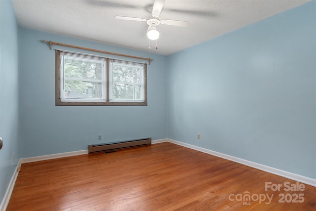 1405 8th Ave NW, Conover, NC 28613 - spare room featuring a baseboard heating unit, wood finished floors, baseboards, and ceiling fan