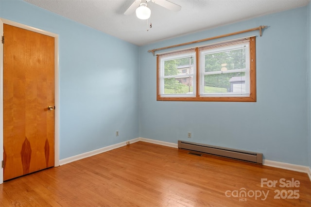 1405 8th Ave NW, Conover, NC 28613 - spare room featuring a baseboard heating unit, wood finished floors, ceiling fan, and baseboards