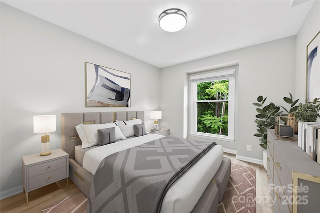 bedroom featuring wood finished floors and baseboards