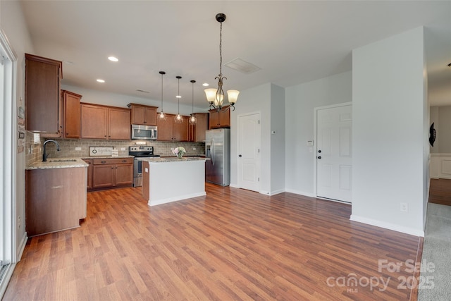 1412 Afternoon Sun Rd, Matthews, NC 28104 - kitchen featuring appliances with stainless steel finishes, backsplash, a kitchen island, wood finished floors, and recessed lighting