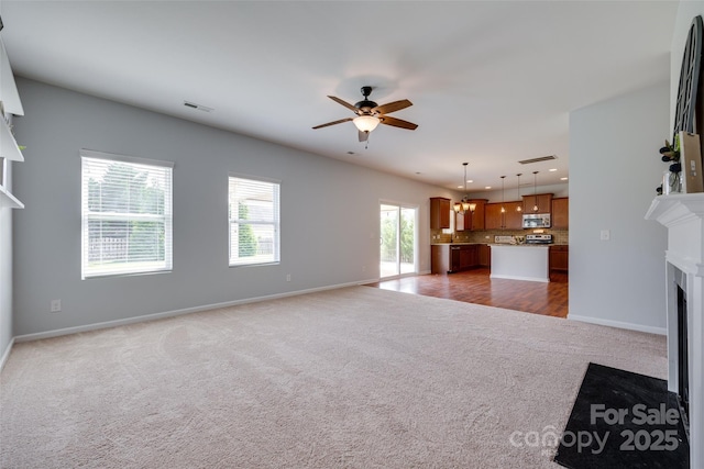 1412 Afternoon Sun Rd, Matthews, NC 28104 - unfurnished living room with carpet floors, a fireplace with flush hearth, ceiling fan, recessed lighting, and a chandelier