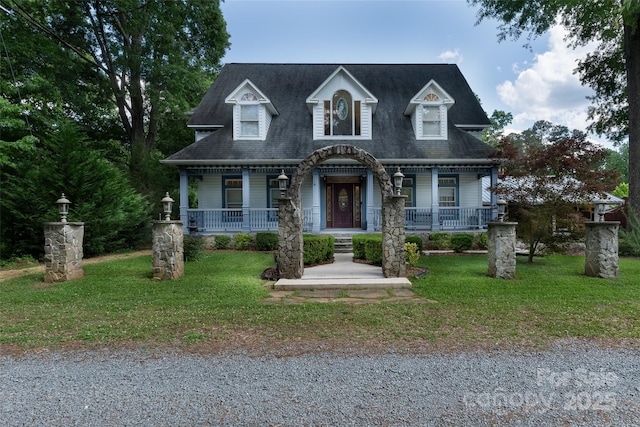cape cod home featuring covered porch, a front yard, and roof with shingles