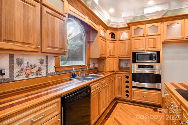kitchen featuring appliances with stainless steel finishes, wooden counters, a sink, glass insert cabinets, and decorative backsplash