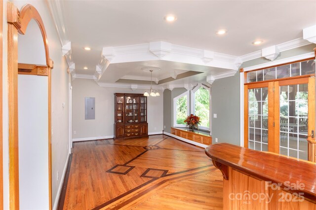 entrance foyer with crown molding, baseboards, a chandelier, electric panel, and light wood-style floors