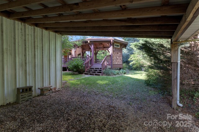 view of green lawn featuring a wooden deck and stairway