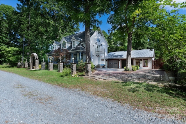 view of front of home with an attached garage, driveway, and metal roof