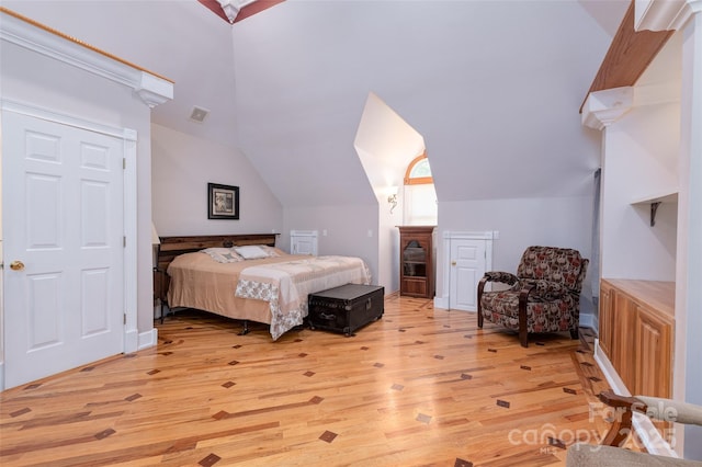bedroom featuring light wood finished floors and lofted ceiling