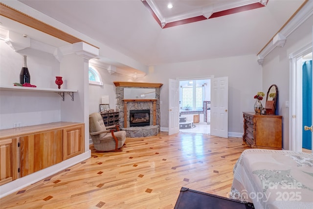 bedroom with light wood finished floors, a stone fireplace, crown molding, baseboards, and recessed lighting