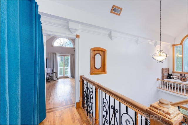 hallway featuring light wood finished floors and crown molding