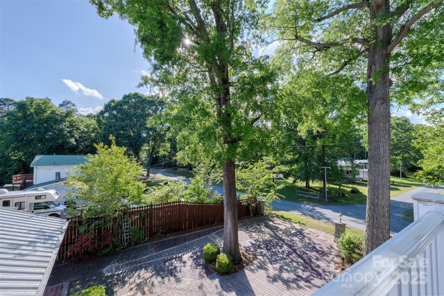 view of patio / terrace with fence and view of wooded area