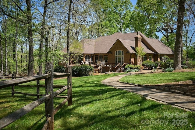 view of front facade with a front lawn and a wooden deck