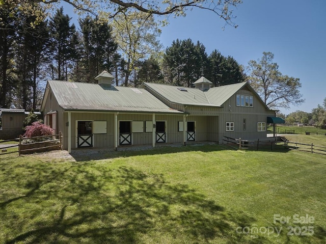 rear view of house featuring an exterior structure, metal roof, an outbuilding, and board and batten siding