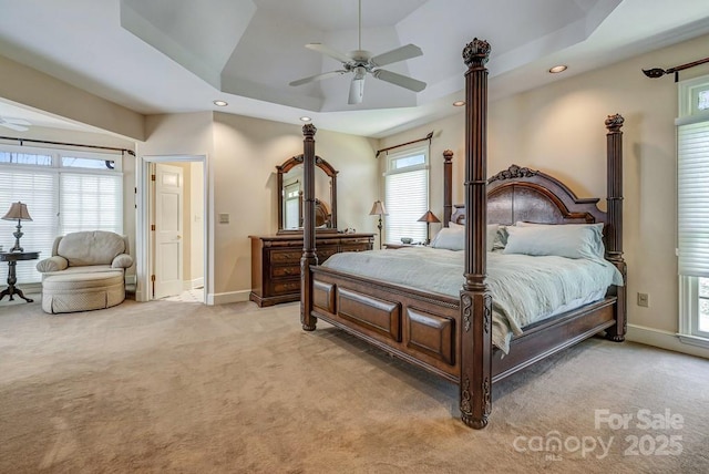 bedroom with light colored carpet, recessed lighting, a raised ceiling, baseboards, and a ceiling fan