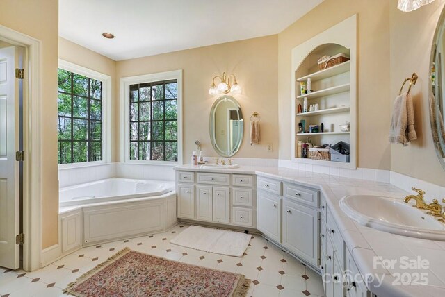 full bathroom with vanity, a bath, tile patterned floors, and built in shelves