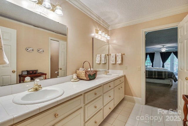 bathroom with double vanity, ensuite bathroom, a textured ceiling, tile patterned flooring, and ornamental molding