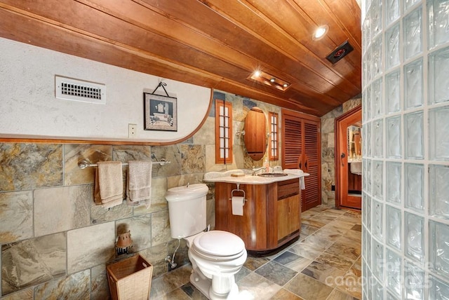 bathroom featuring toilet, wood ceiling, vanity, and tile walls