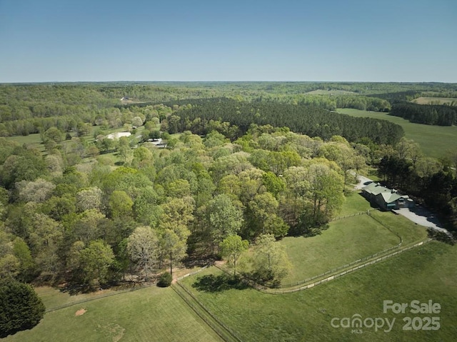 aerial view of property and surrounding area with a forest