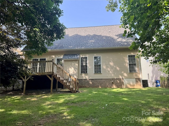 rear view of property with a wooden deck, stairs, a lawn, and a shingled roof