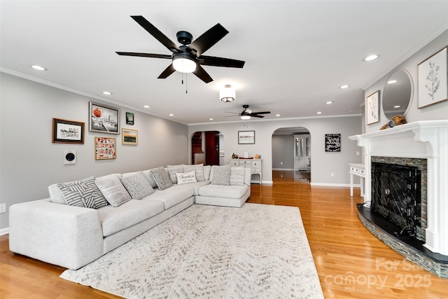 3407 Patton Rd, Franklin, NC 28734 - living room featuring arched walkways, ceiling fan, recessed lighting, light wood-style floors, and crown molding