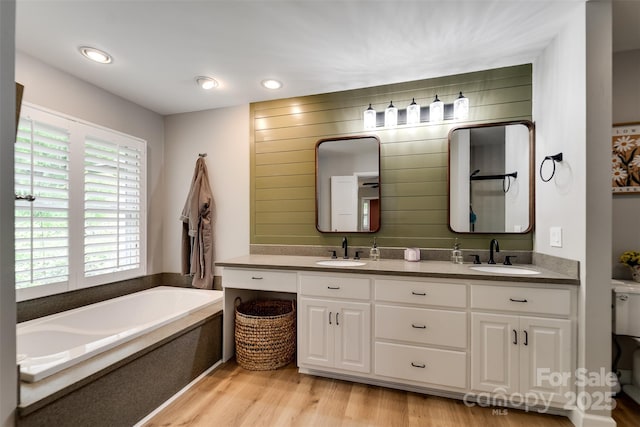 3407 Patton Rd, Franklin, NC 28734 - bathroom with a garden tub, double vanity, wood finished floors, and toilet