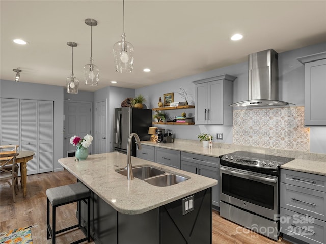 118 Cloverleaf Ln, Asheville, NC 28803 - kitchen with wall chimney range hood, stainless steel appliances, a sink, gray cabinets, and a center island with sink
