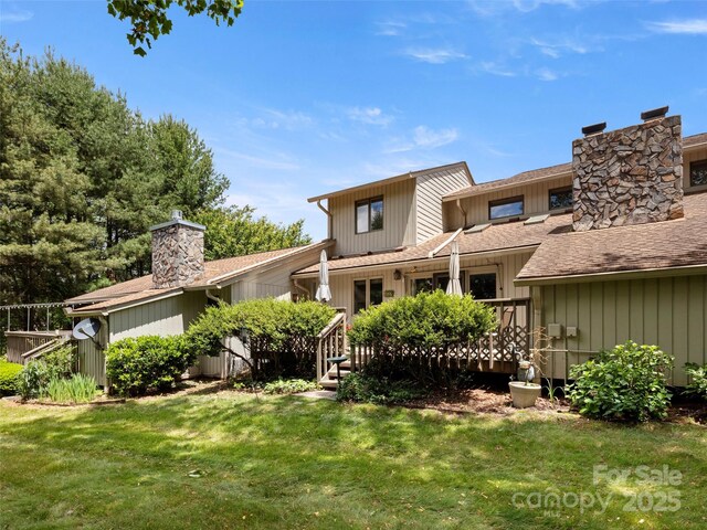 118 Cloverleaf Ln, Asheville, NC 28803 - back of property featuring a chimney, a lawn, a wooden deck, and a shingled roof