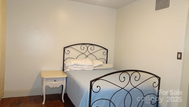 bedroom with dark wood-type flooring and baseboards