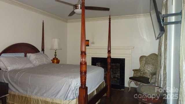 bedroom with a fireplace, wood finished floors, ceiling fan, and crown molding