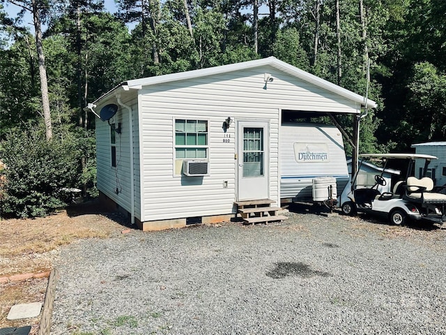view of front of property featuring entry steps, crawl space, cooling unit, and view of wooded area