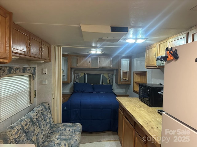 bedroom featuring freestanding refrigerator