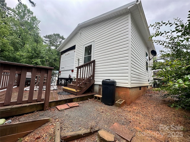 rear view of property featuring entry steps and a wooden deck
